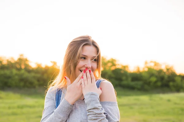 Verrast jonge vrouw die betrekking hebben op haar mond met handen buitenshuis — Stockfoto