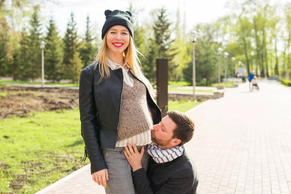 Conceito de gravidez elegante - retrato de casal de hipsters marido e mulher em roupas da moda andando no parque da cidade — Fotografia de Stock