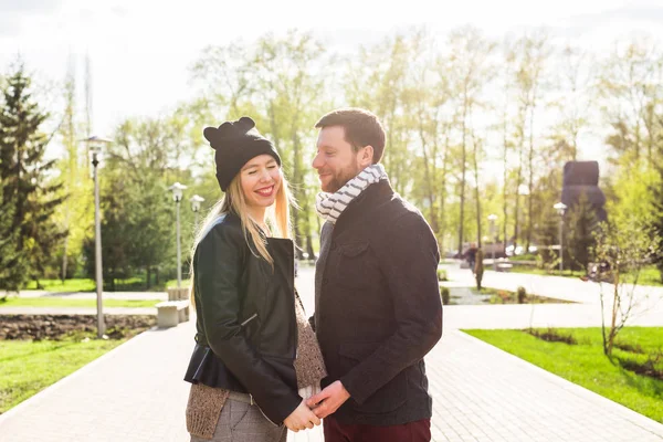 Concepto de embarazo con estilo - retrato de un par de hipsters marido y mujer en ropa de moda caminando por el parque de la ciudad — Foto de Stock