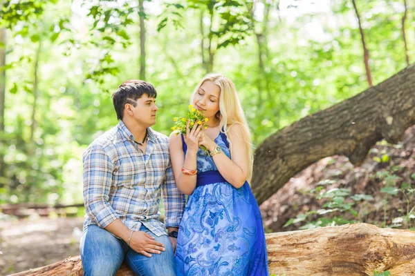 Ung man ger en blomma maskros till Flickvän utomhus — Stockfoto