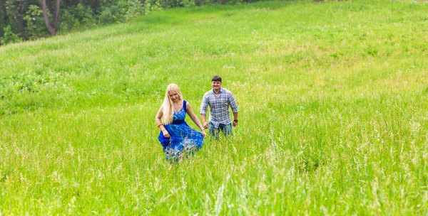 Ευτυχισμένο ζευγάρι τρέχει σε ένα λιβάδι στην καλοκαιρινή φύση — Φωτογραφία Αρχείου