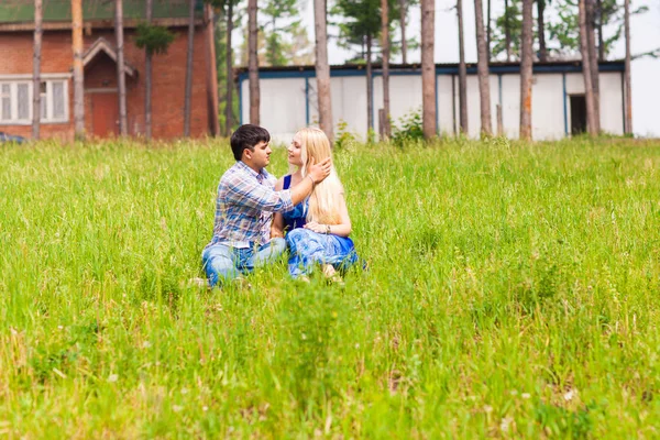 Счастливая молодая пара отдыхает на лужайке в летнем парке. Концепция любви. Отпуск . — стоковое фото