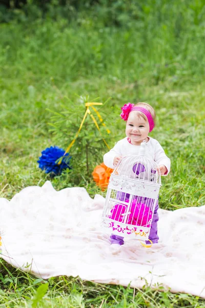 Baby girl playing on the green grass, family picnic close-up — Stock Photo, Image