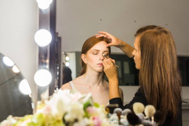 Makyaj sanatçısı arkadaşı üzerinde çalışır. Gerçek insanlar..