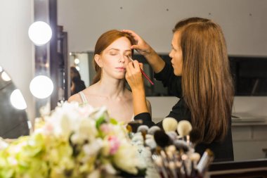 Makyaj sanatçısı arkadaşı üzerinde çalışır. Gerçek insanlar..