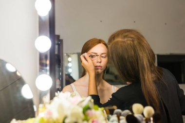 Makyaj sanatçısı arkadaşı üzerinde çalışır. Gerçek insanlar..