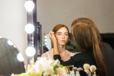 Makyaj sanatçısı arkadaşı üzerinde çalışır. Gerçek insanlar..