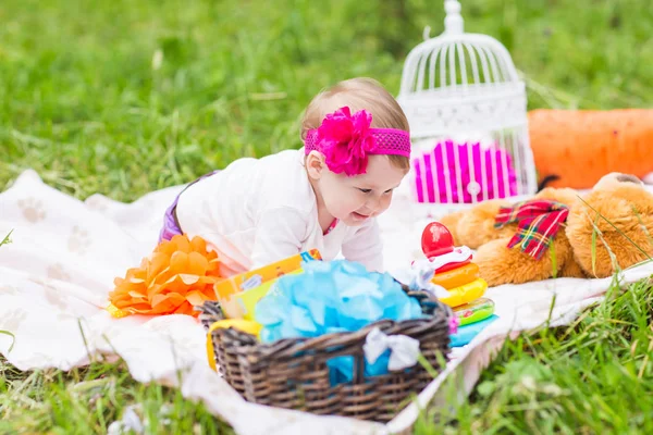 baby girl playing on the green grass, family picnic close-up