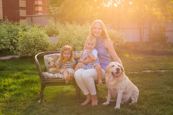 幸せな母と庭でゴールデン ・ リトリーバー犬と 2 人の子供. — ストック写真
