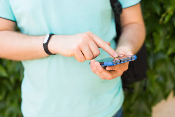 Zbliżenie dłoni mens fitness tracker i inteligentny telefon na zewnątrz — Zdjęcie stockowe