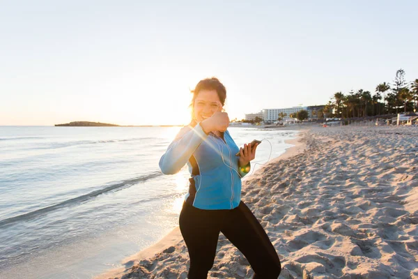 Мотивована спортивна жінка робить жест успіху після міських тренувань на березі моря . — стокове фото