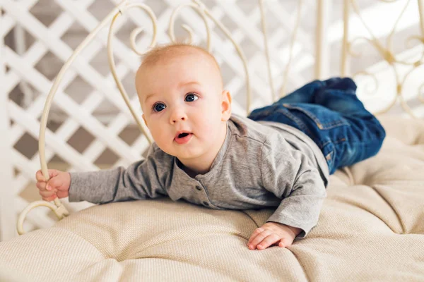 Adorable bebé en el dormitorio soleado. Niño recién nacido relajándose. Guardería infantil para niños pequeños.Mañana familiar en casa. Niñito acostado boca abajo — Foto de Stock