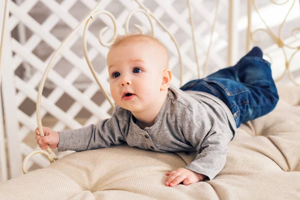 Adorable bebé en el dormitorio soleado. Niño recién nacido relajándose. Guardería infantil para niños pequeños.Mañana familiar en casa. Niñito acostado boca abajo — Foto de Stock