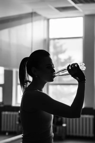 Tiempo de descanso. Silueta de chica deportiva beber agua. Foto del modelo fitness. Concepto de salud . — Foto de Stock