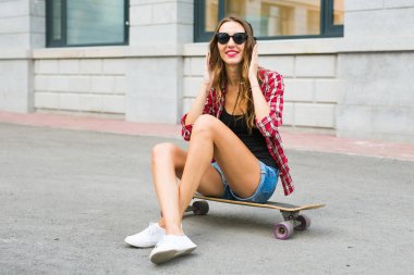 Kaykay üzerinde oturan güzel ve seksi kız