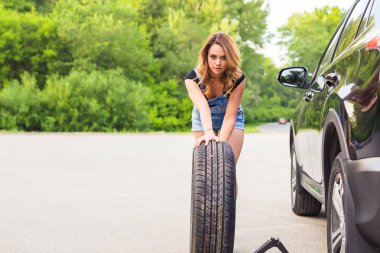 Seksi kadın tekerlek yol kenarında üzerinde değiştirme