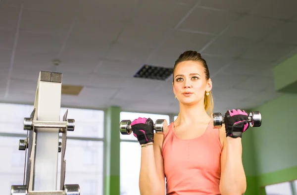 Sportig ung kvinna med hantlar i gymmet — Stockfoto