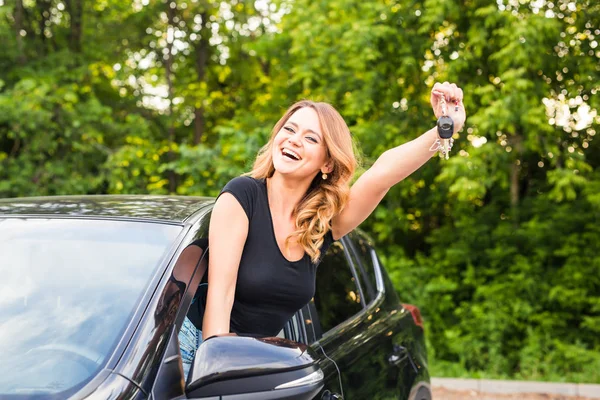 Mujer feliz conductor sostiene las llaves del coche en su nuevo coche — Foto de Stock
