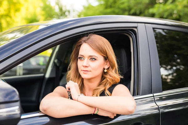 Porträt einer lächelnden jungen Frau am Steuer eines Autos — Stockfoto