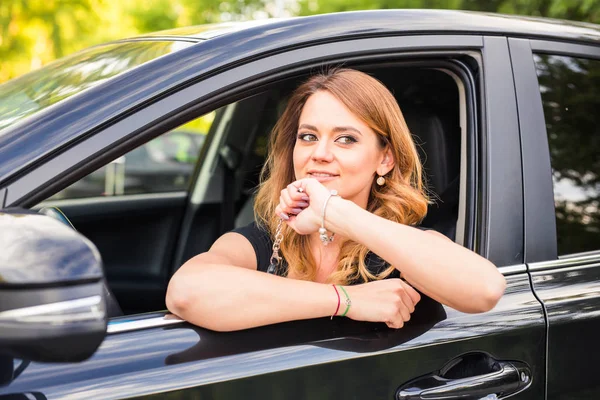 Junge glückliche Frau im Auto mit Schlüssel in der Hand - Konzept des Autokaufs. — Stockfoto