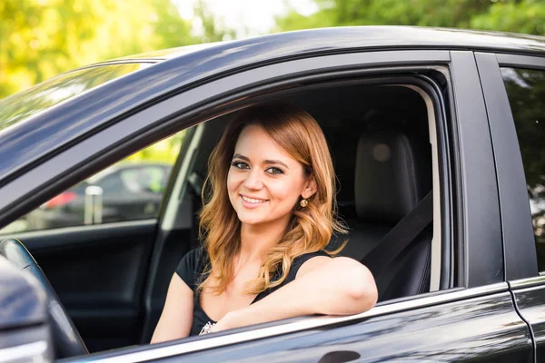 Porträt einer lächelnden jungen Frau am Steuer eines Autos — Stockfoto