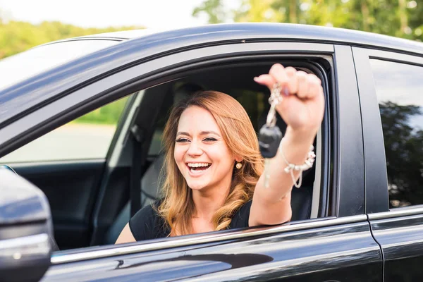 Junge fröhliche, fröhlich lächelnde, hinreißende Frau, die die Schlüssel zu ihrem ersten neuen Auto hochhält. Kundenzufriedenheit — Stockfoto