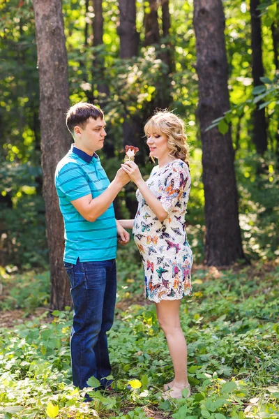 Feliz joven embarazada pareja abrazándose en la naturaleza —  Fotos de Stock