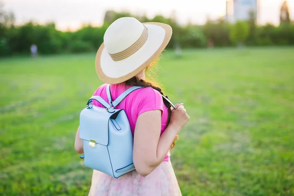 Junge Frau mit blauem Rucksack und Hut genießt die Aussicht auf die Landschaft — Stockfoto