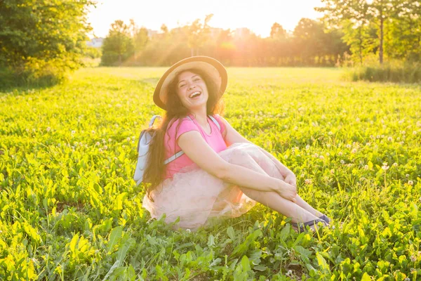 Schöne junge lachende ungezogene Frau, die draußen sitzt und lächelt — Stockfoto