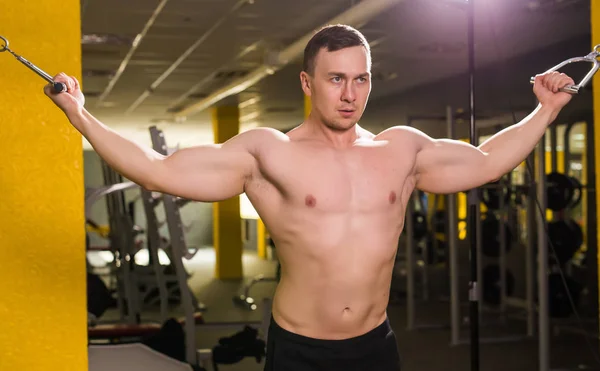 Pohledný mladý svalnatý muž trénink v tělocvičně. — Stock fotografie