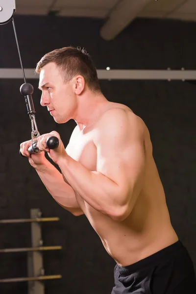 Pohledný mladý svalnatý muž trénink v tělocvičně. — Stock fotografie