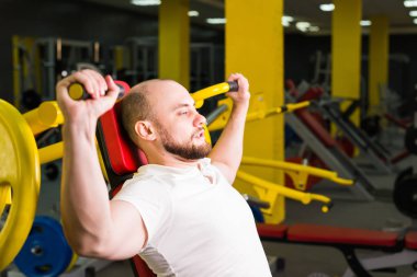 Atletik erkek güç egzersiz makinesi bir spor kulübü ile egzersiz yapıyor.