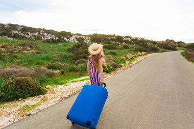 Yaz, tatil, seyahat ve özgürlük kavramı - mavi çanta yolda yürüyen Traveler kadın