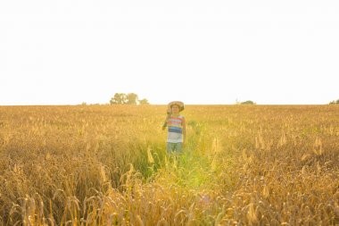 Genç hipster adam bir doğada, yürüme ile bir gitar tutan güneşli bir günde alanında rahatlatıcı.