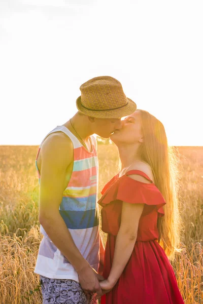 Jeune couple d'amour embrasser sur le terrain dans la lumière du soleil — Photo