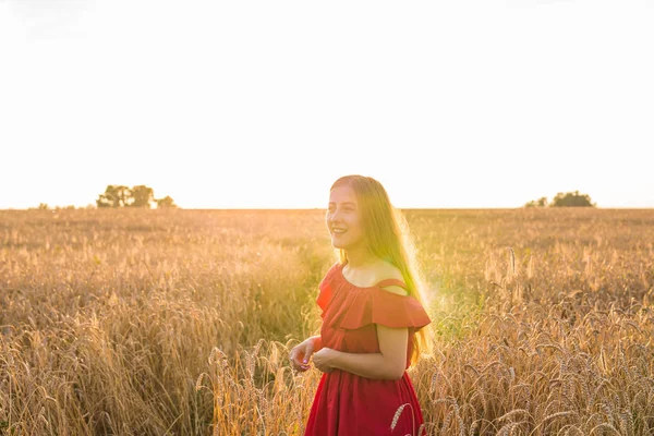 Belle jeune femme dans le champ de blé au coucher du soleil — Photo