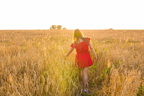 Χώρα, φύση, καλοκαίρι διακοπές, διακοπές και άνθρωποι έννοια - ευτυχισμένος νεαρή γυναίκα στο κόκκινο φόρεμα σε στον τομέα των δημητριακών — Φωτογραφία Αρχείου
