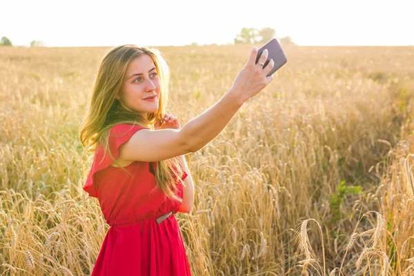 Mutlu kadın alanında cep telefonu ile selfie resim çekerken gülümseyen