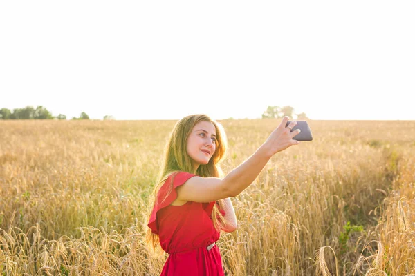 Mutlu kadın alanında cep telefonu ile selfie resim çekerken gülümseyen