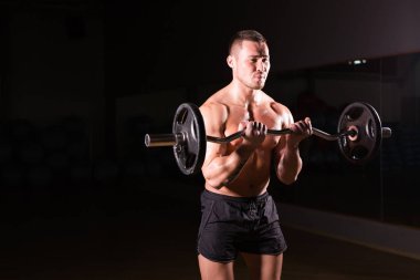 Barbell ile eğitim emin kaslı adam. Portre portre profesyonel vücut geliştirmeci egzersiz halter vasıl jimnastik salonu ile.