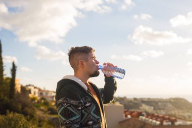 Bir adam içme suyu bir şişe dışında portresi