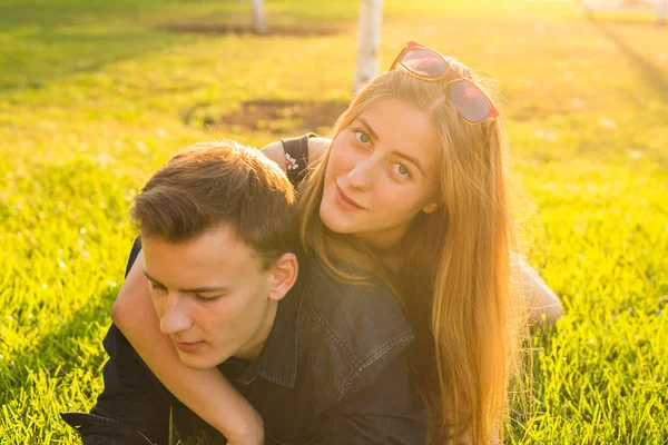 Schönes junges glückliches Paar, das Spaß im Gras hat. — Stockfoto