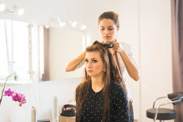 Concept de beauté et de personnes - heureuse jeune femme avec coiffeur au salon de coiffure . — Photo