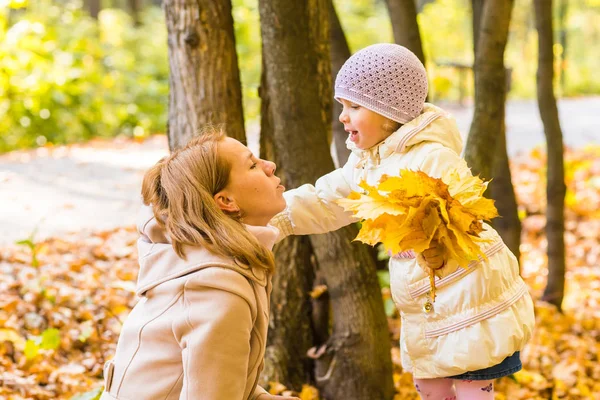 Молодая мать играет со своей дочерью в осеннем парке . — стоковое фото