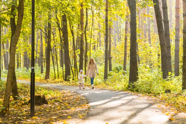 Mãe e filha caminhando no parque de outono — Fotografia de Stock