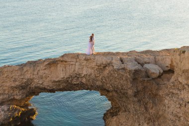 güzel güzel gelin ve şık Damat Düğün töreni Kıbrıs rocks, arka planda bir denizin üzerinde