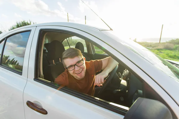 Atraktivní mladý šťastný muž ukazuje své nové klíče od auta a směje se — Stock fotografie