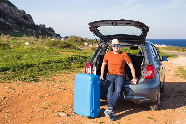 Cestování, dovolená, letní výlet a lidé koncept - muž jde na dovolenou, kufry v kufru auta — Stock fotografie