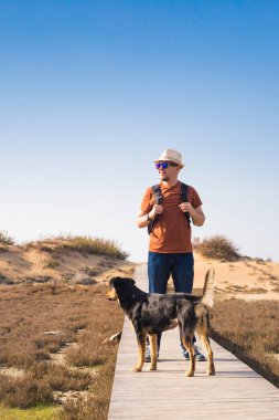 Güzel manzara ile giden bir yolda Köpeğiyle yürüyen adam
