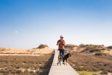 Güzel manzara ile giden bir yolda Köpeğiyle yürüyen adam